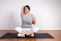 overweight-woman-exercising-stretching-home-22755791